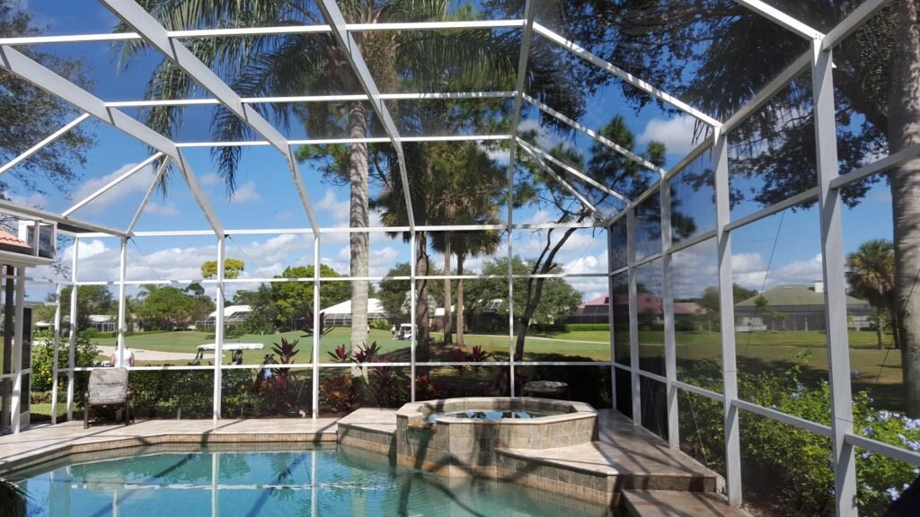 Pool cage rescreening service in New Smyrna, FL enclosing backyard spa area