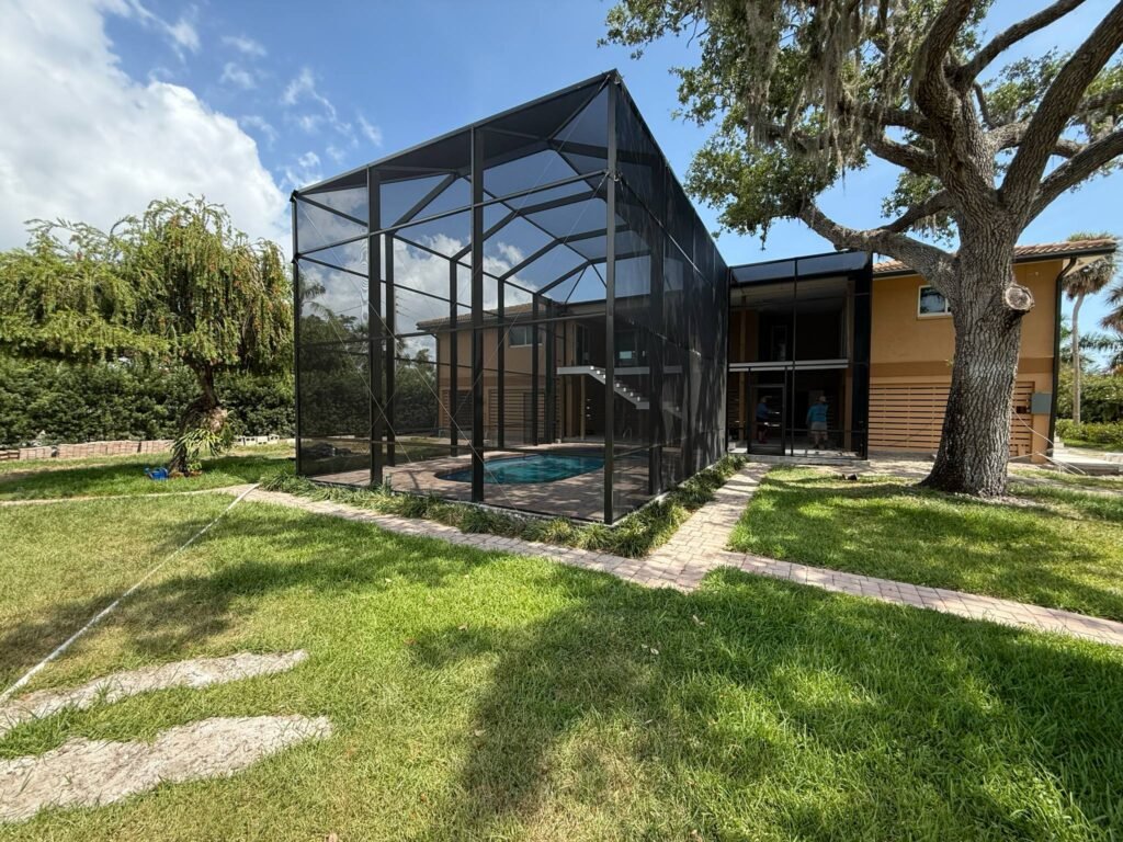 Custom screen enclosure installation in New Smyrna, FL surrounding backyard pool area